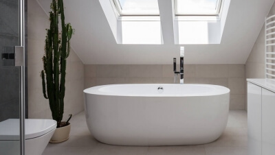 Badezimmer mit großer Wanne und Dusche unter einer Dachschräge